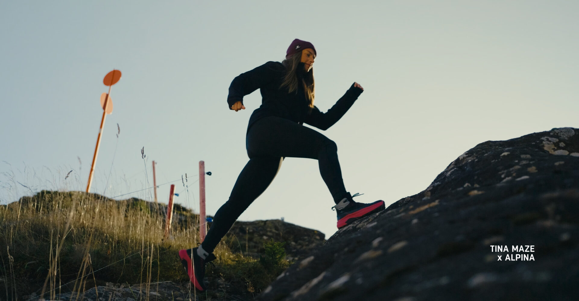 Tina Maze running across rocky terrain in Alpina low-cut hiking shoes