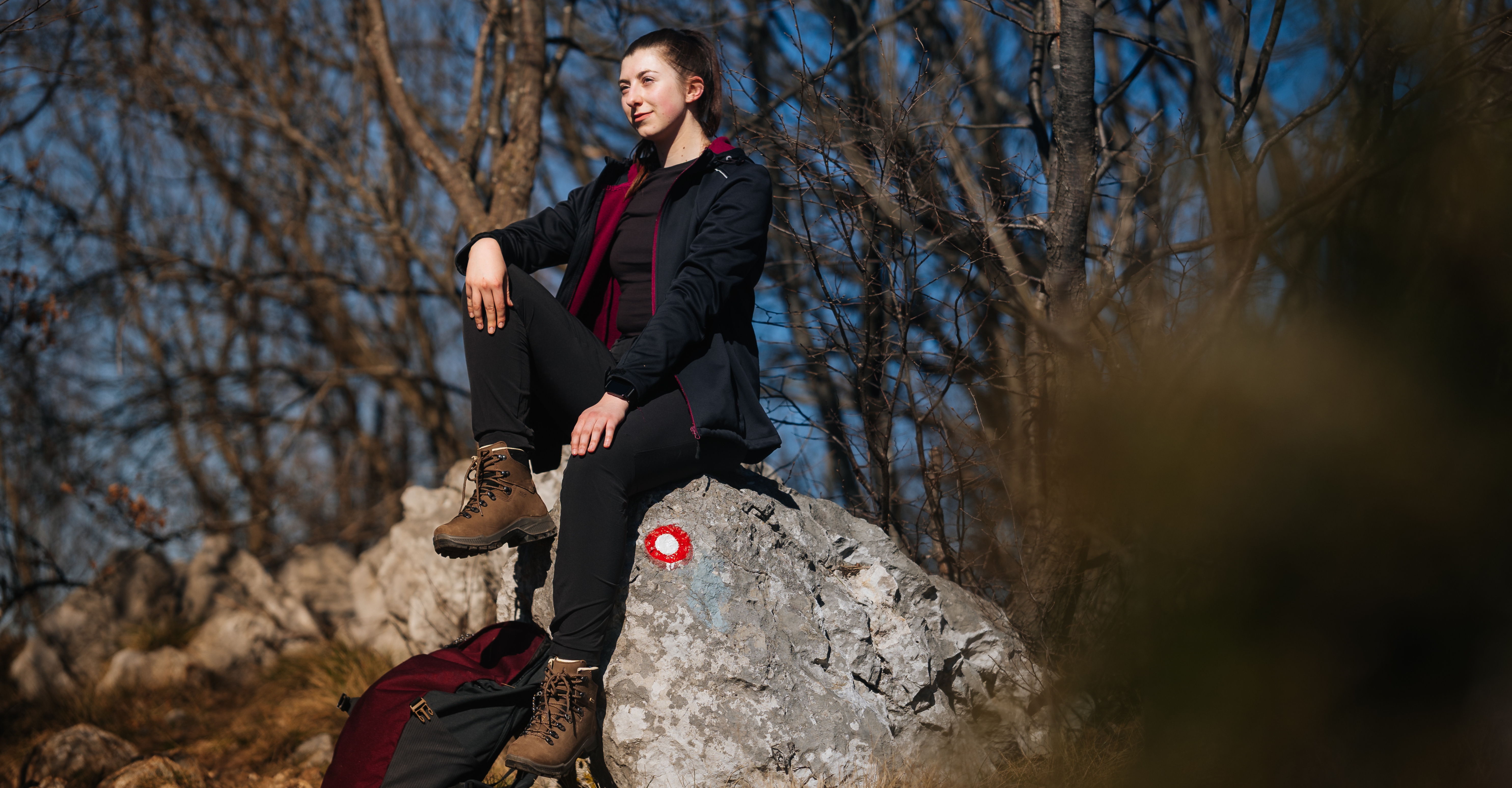 Woman sitting on a rock in Alpina high-cut hiking boots