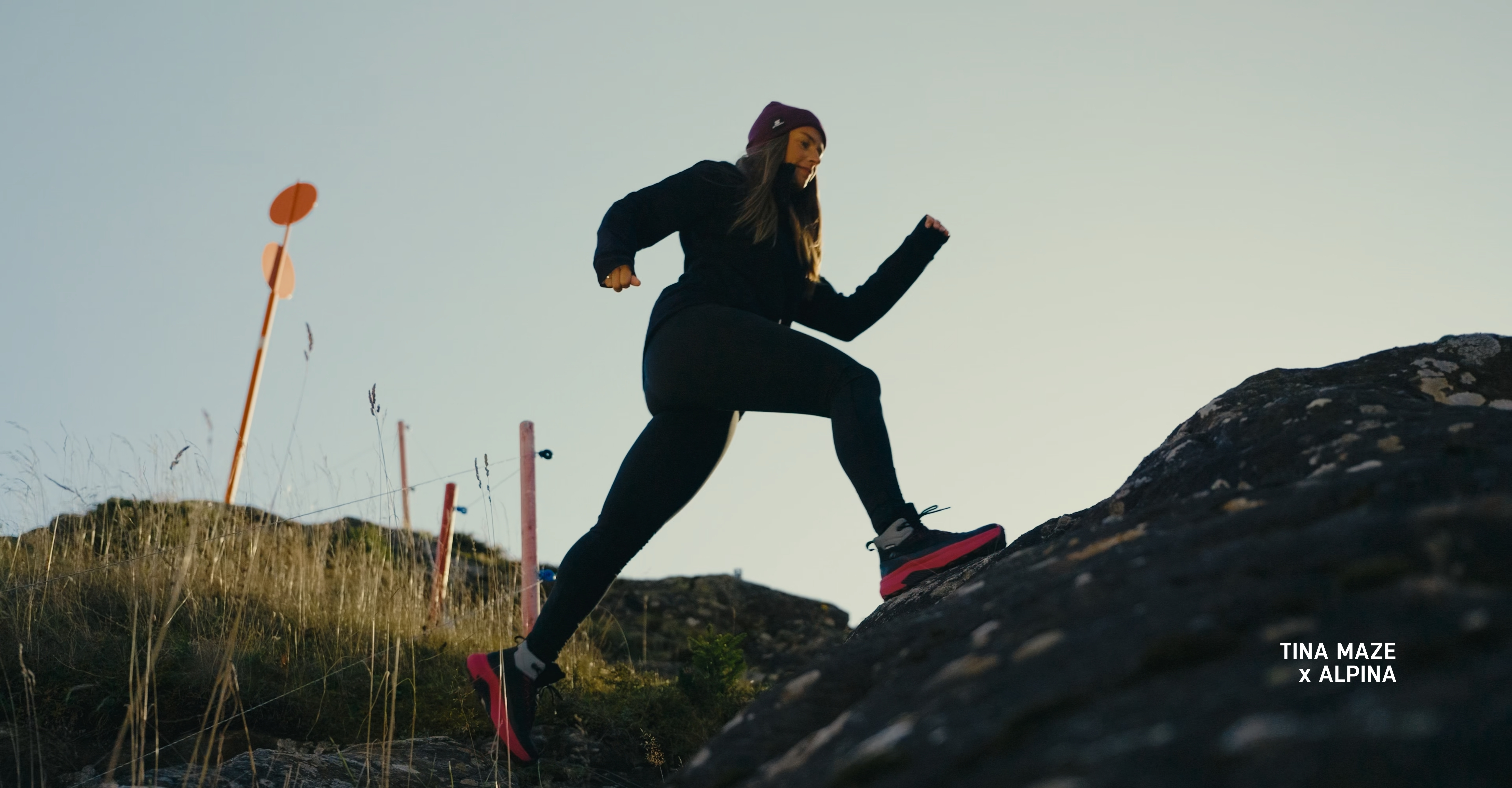 Tina Maze running across rocky terrain in Alpina low-cut hiking shoes